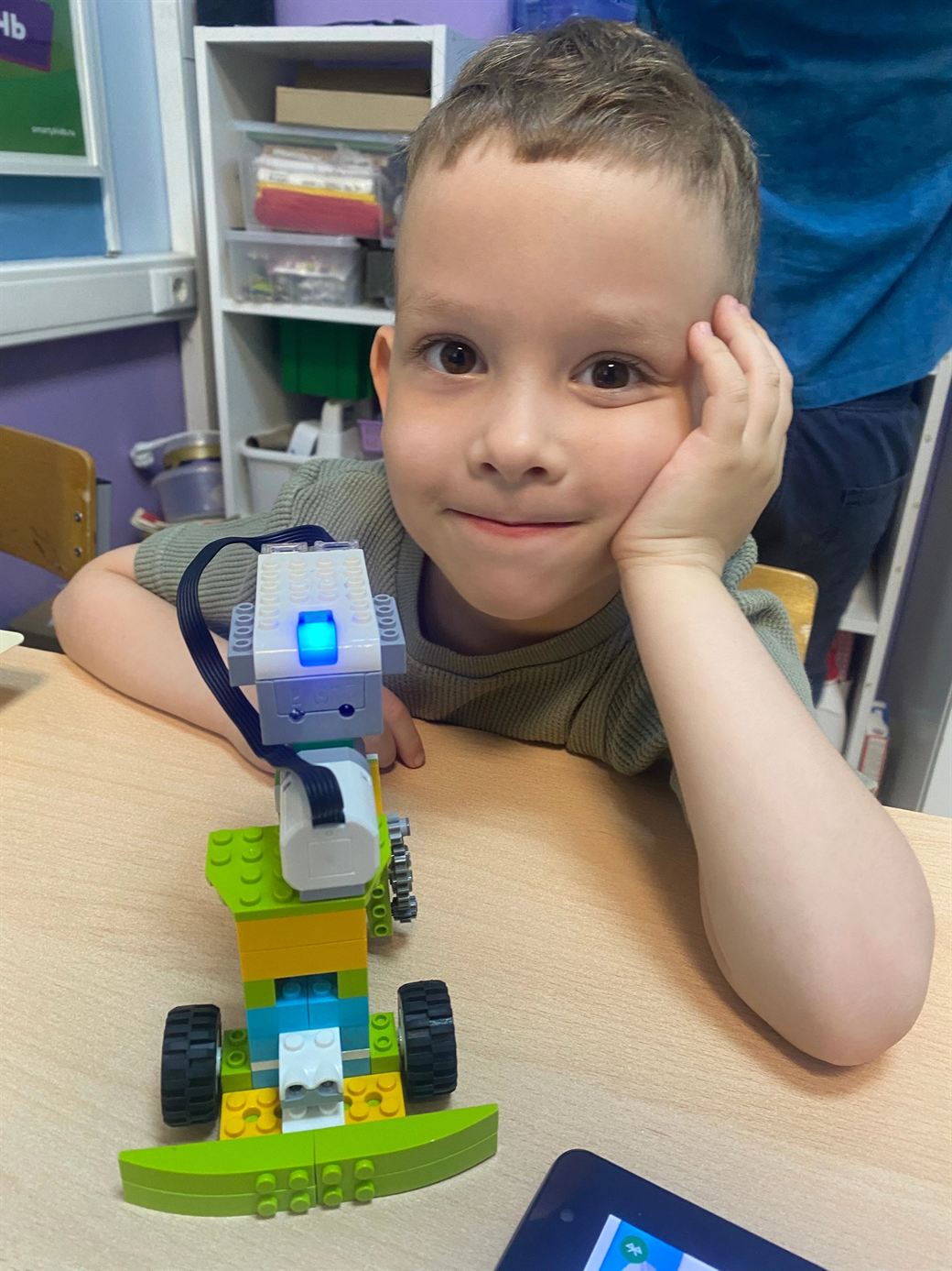 Ученик рядом с роботом LEGO WeDo с включённым датчиком
